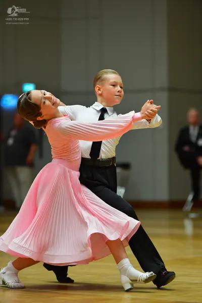 Dancesport competitor: Female dancer: light pink long-sleeved ballroom dress with a pleated skirt