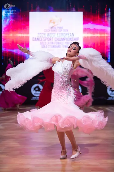 Dancesport competitor: Main dancer: white/light pink latin dress with heavy sequin embellishments on th