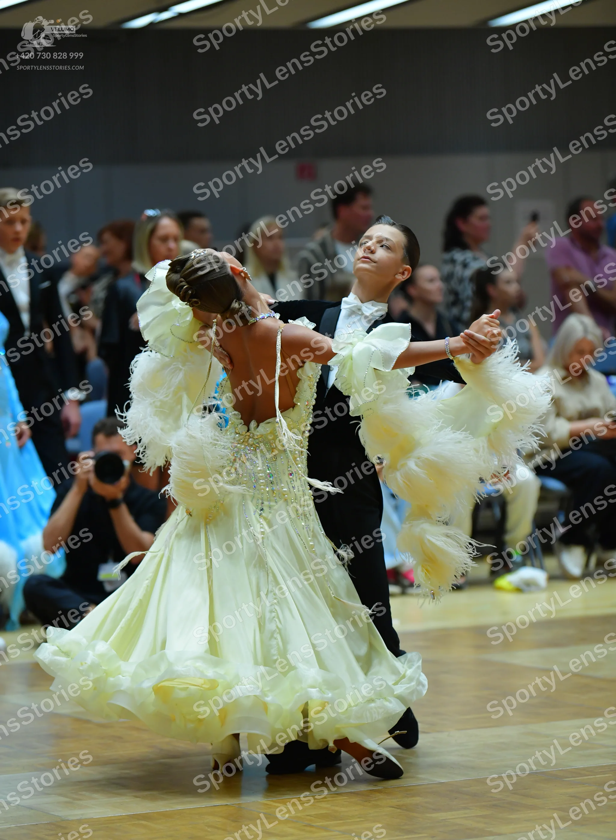 Dancesport competitor: Female dancer: pale yellow ballroom gown with a heavily embellished bodice and a