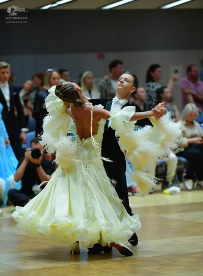 Dancesport competitor: Female dancer: pale yellow ballroom gown with a heavily embellished bodice and a