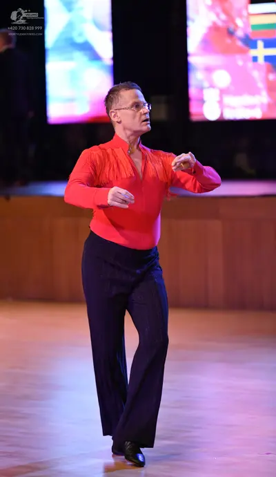 Dancesport competitor: Male dancer: red long-sleeved latin dance shirt with fringe on the chest and dar