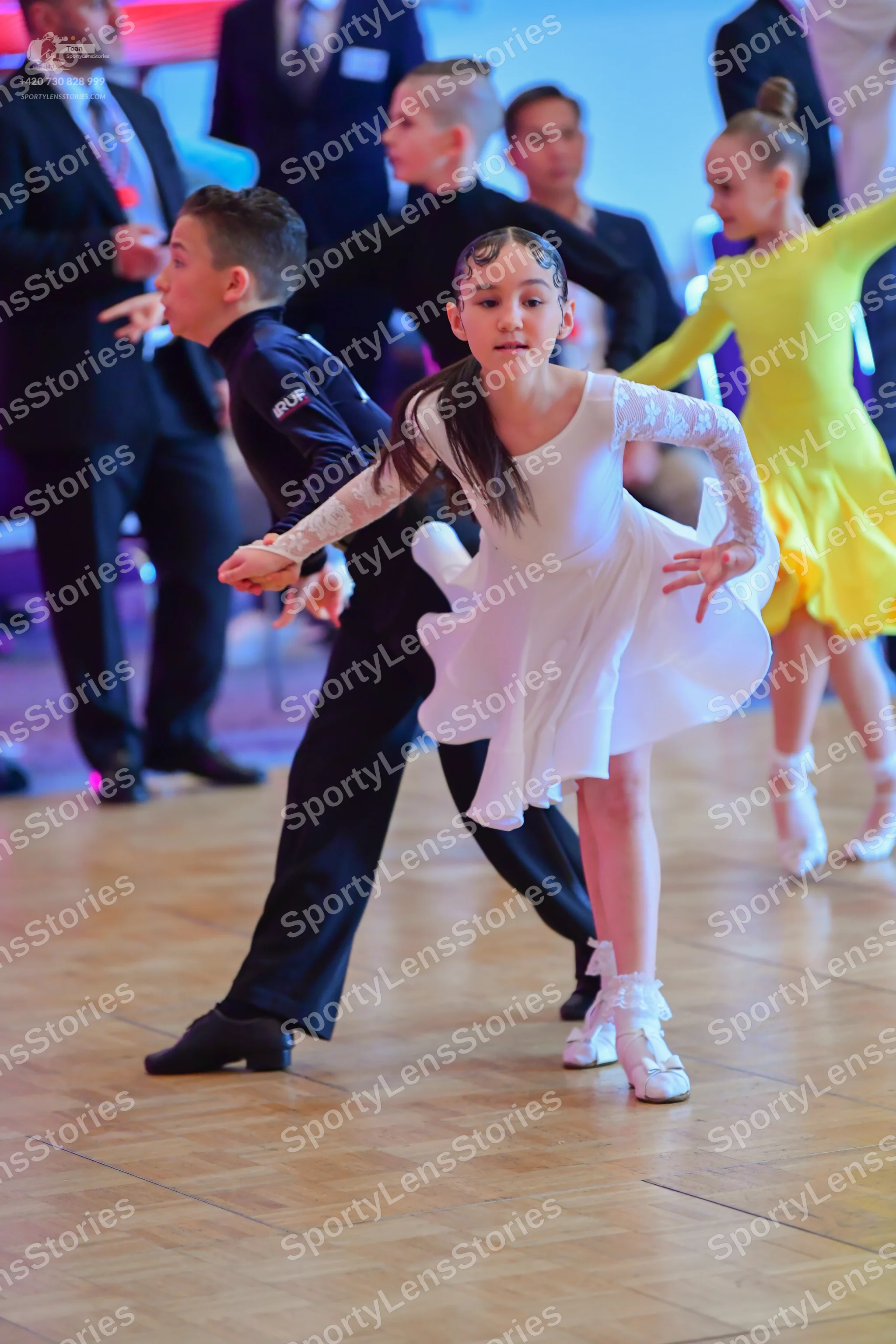 Dancesport competitor: Male dancer: black long-sleeved shirt with "SKF" lettering on the sleeve and bla