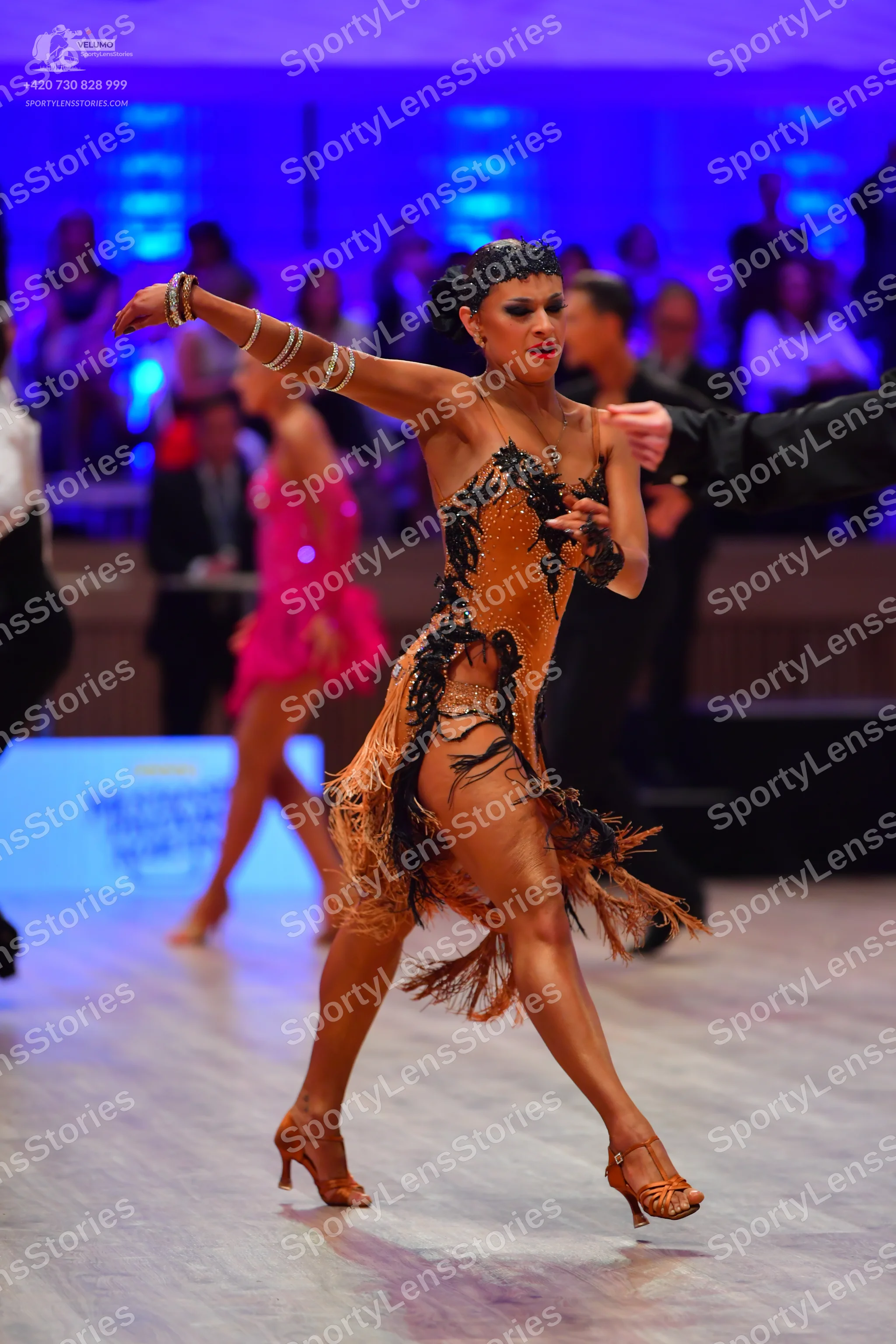 Dancesport competitor: Main female dancer: nude-colored Latin dance dress with black sequin/lace patter