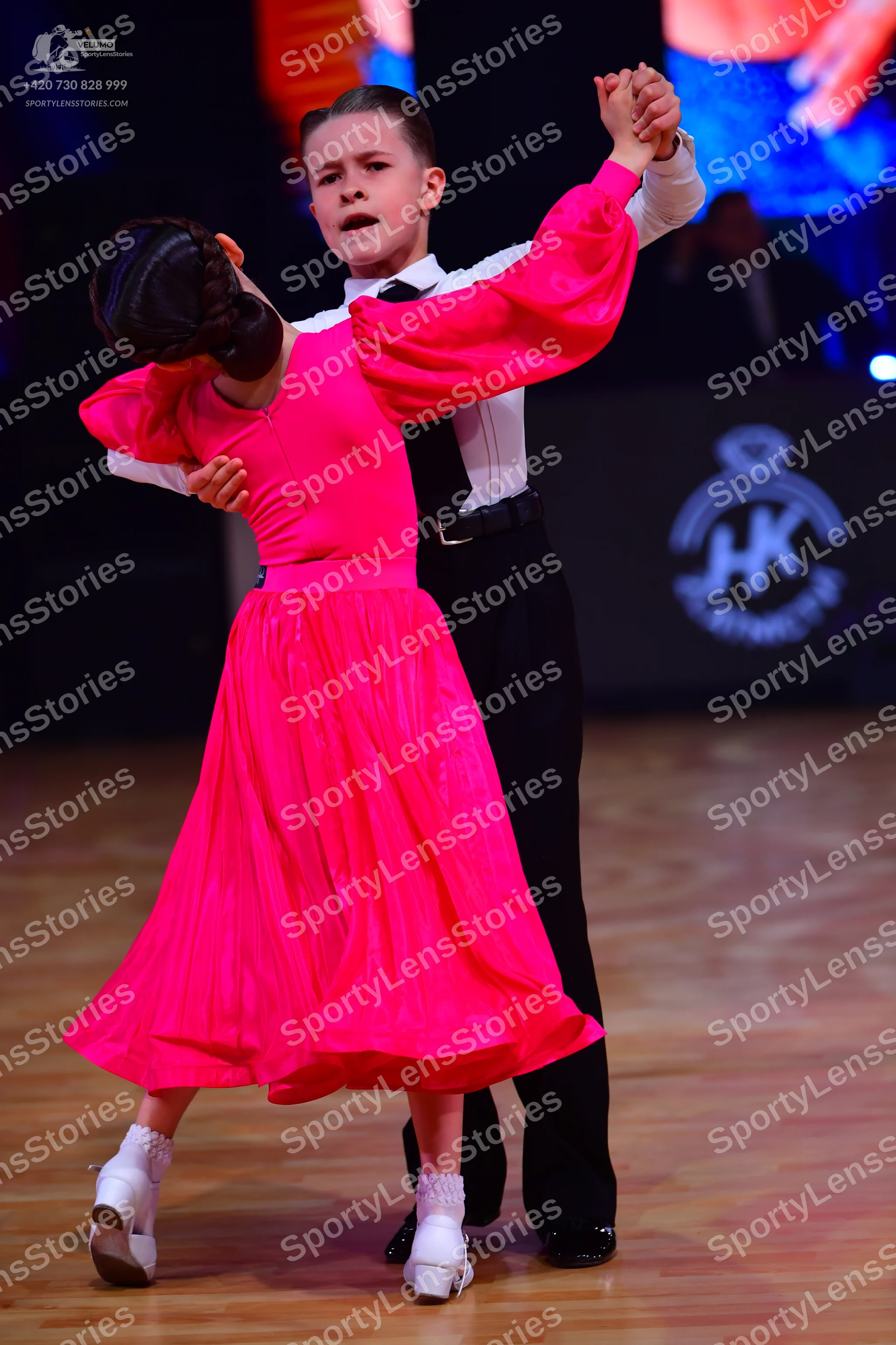 Dancesport competitor: Female dancer: bright pink long-sleeved dress with a full, flowing skirt