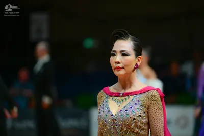 Dancesport competitor: Female dancer: nude-colored bodice heavily embellished with multicolored rhinest