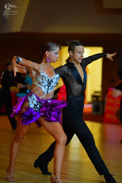 Dancesport competitor: Female dancer: white, purple, and black latin dress with sequin/crystal embellis