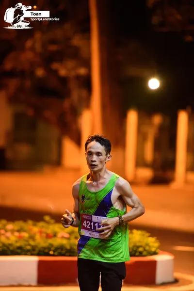 Marathon runner #42117: Runner 1: green sleeveless top with blue accents, black shorts