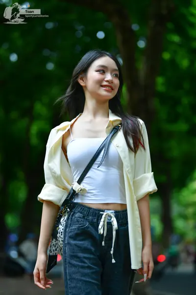 Dancesport competitor: Female dancer: white camisole, light yellow unbuttoned long-sleeved shirt, and d