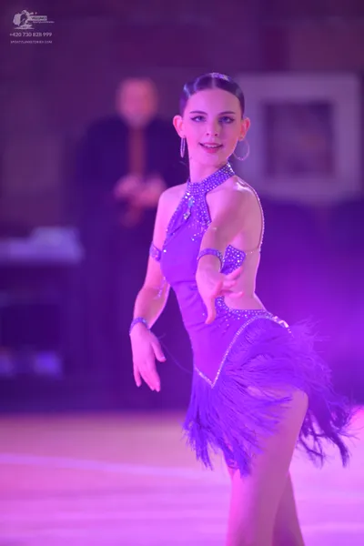 Dancesport competitor: Female dancer: purple Latin dance dress with a high neck, decorated with silver 