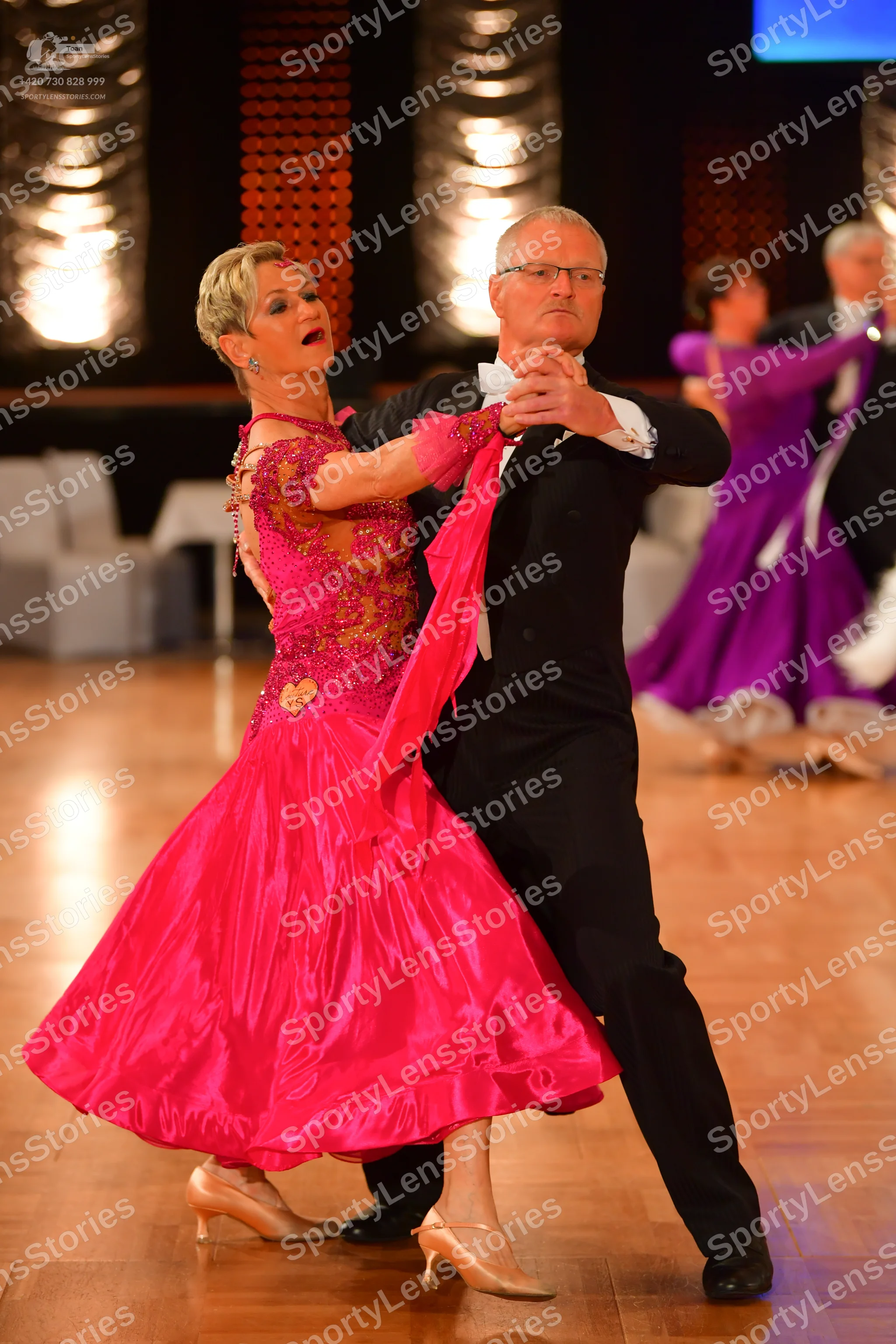 Dancesport competitor: Main female dancer: pink ballgown with a sequined/lace bodice and a satin-like v