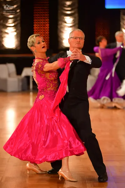 Dancesport competitor: Main female dancer: pink ballgown with a sequined/lace bodice and a satin-like v