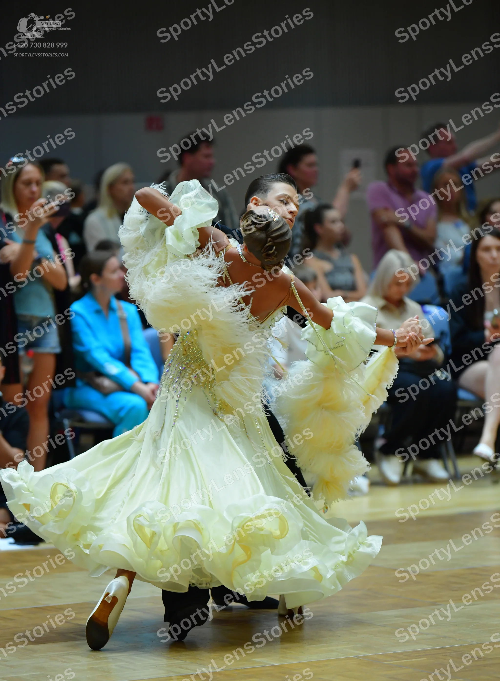 Dancesport competitor: Female dancer: light yellow, voluminous ballgown with many layers of ruffles and