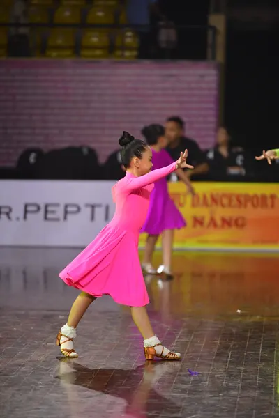 Dancesport competitor: Female dancer: pink latin dress with strappy tan dance shoes