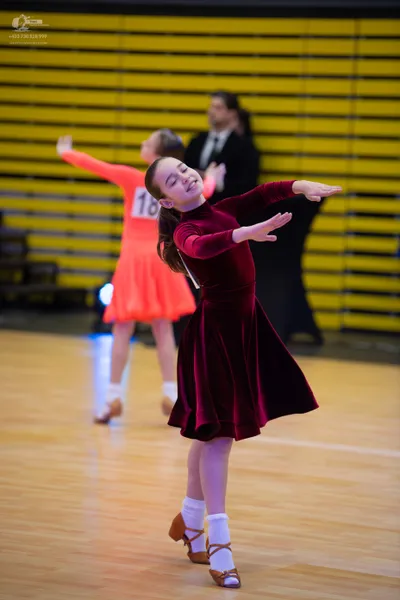 Dancesport competitor: ** Female: Red Latin Dress - The dancer is wearing a vibrant red Latin dress