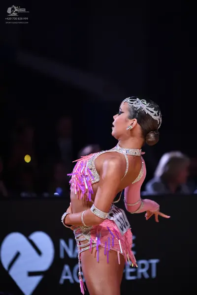Dancesport competitor: Female dancer: pink latin dance costume with silver sequins and long pink fringe