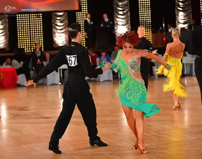 Dancesport competitor #67: Male dancer in foreground: black long-sleeved shirt and black trousers