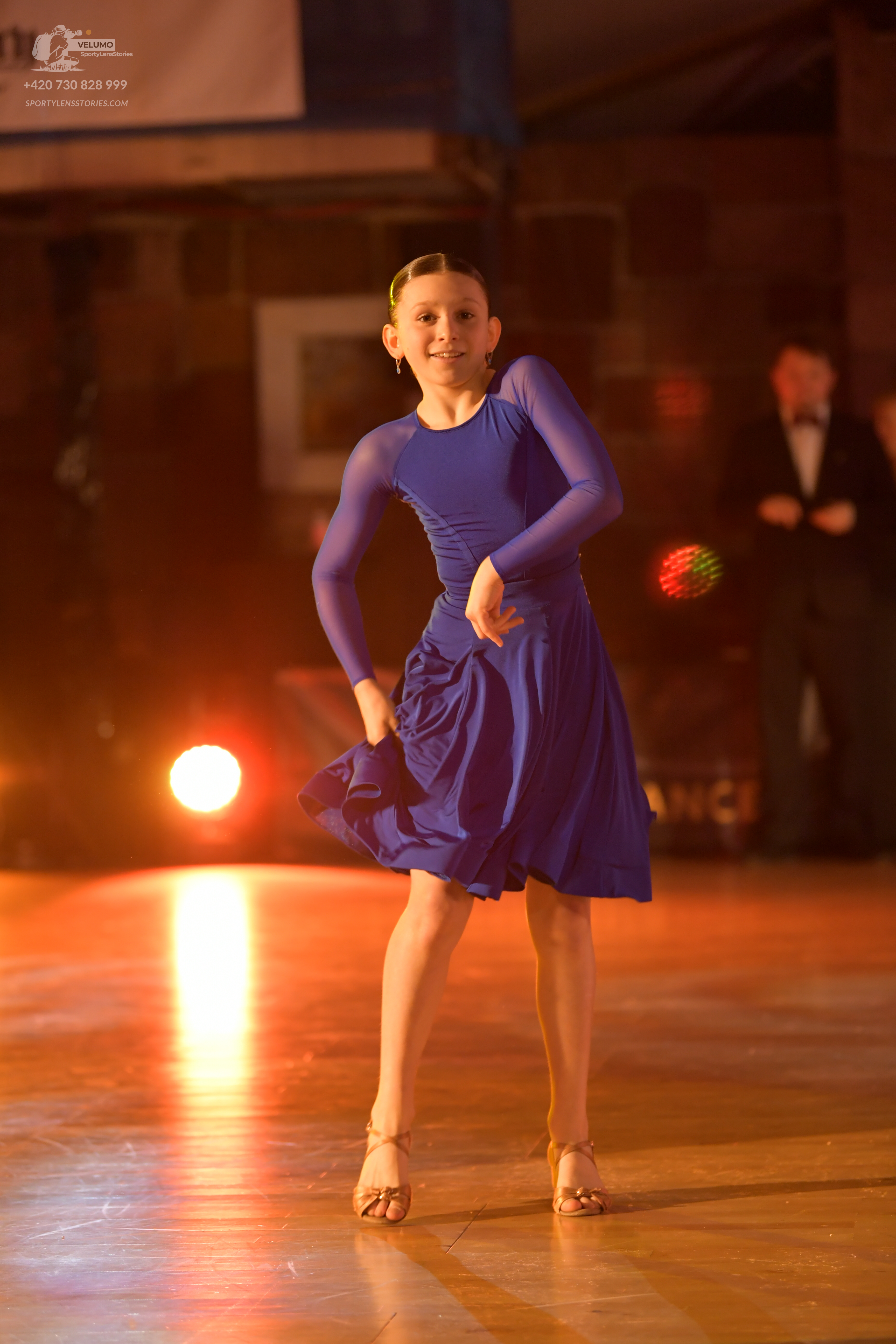 Dancesport competitor: Female dancer: blue long-sleeved dance dress with a knee-length skirt