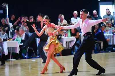 Dancesport competitor: Male dancer: long-sleeved white shirt, black trousers, and black dance shoes
