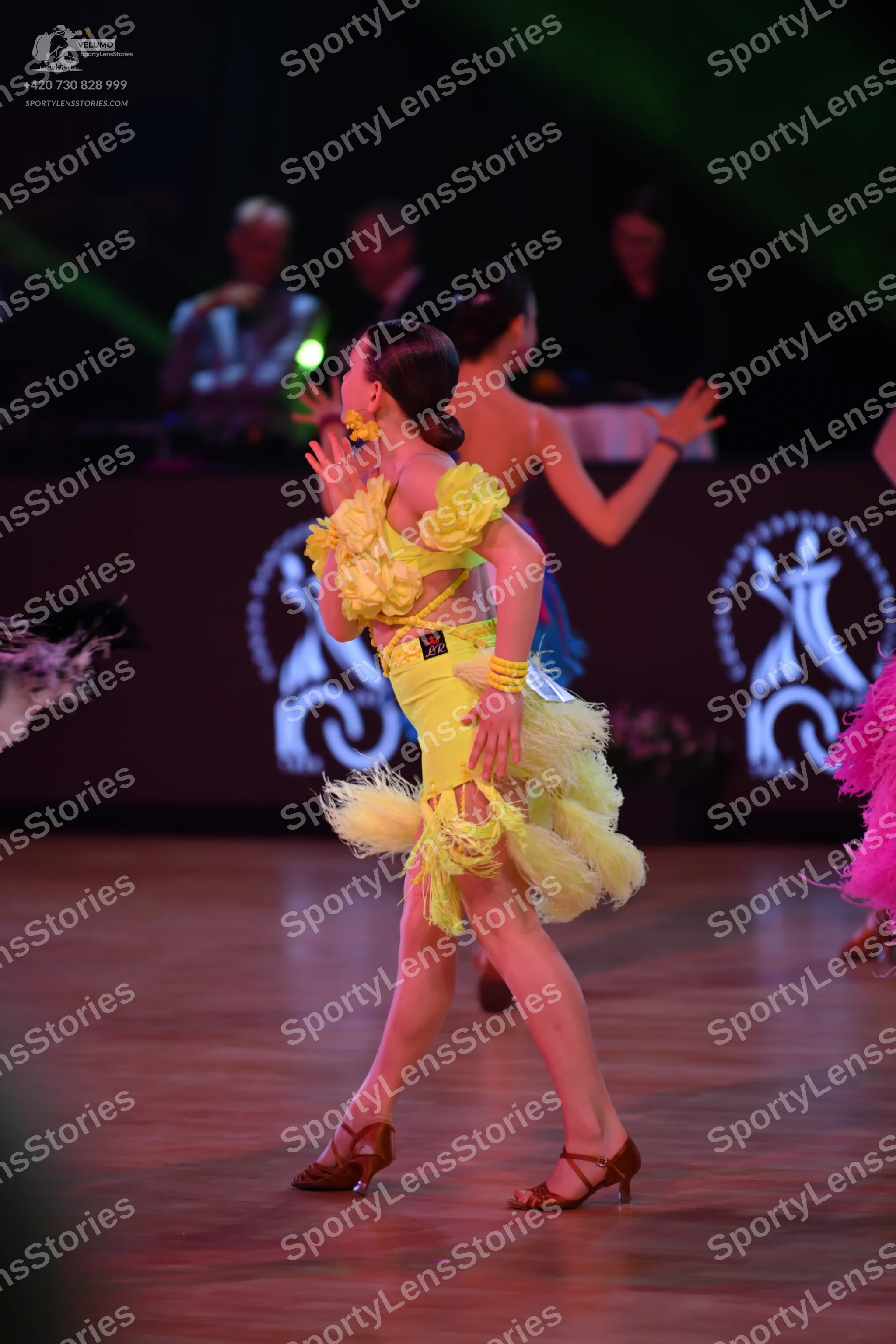 Dancesport competitor: Yellow dancer: yellow Latin dress with large yellow ruffles on the shoulders and