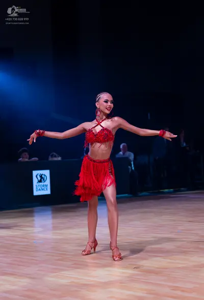 Dancesport competitor: Female dancer: red latin dress with fringe and sequins, red wristbands, and red 