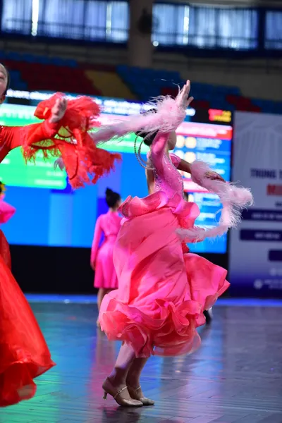 Dancesport competitor: ** Female: Bright pink, voluminous latin dress with a sweetheart neckline, a low