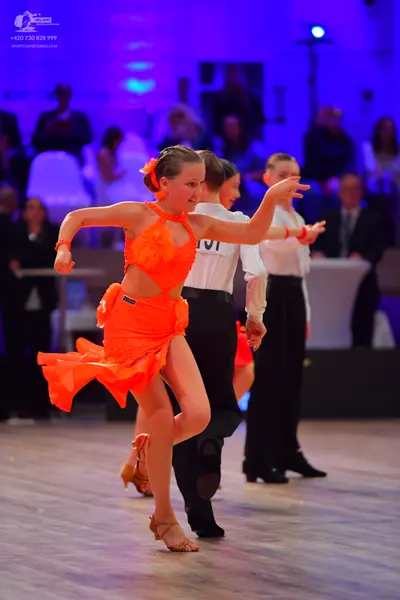 Dancesport competitor: Female dancer: orange Latin dress