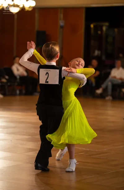 Dancesport competitor: Male dancer: black vest, white long-sleeved shirt, and black trousers