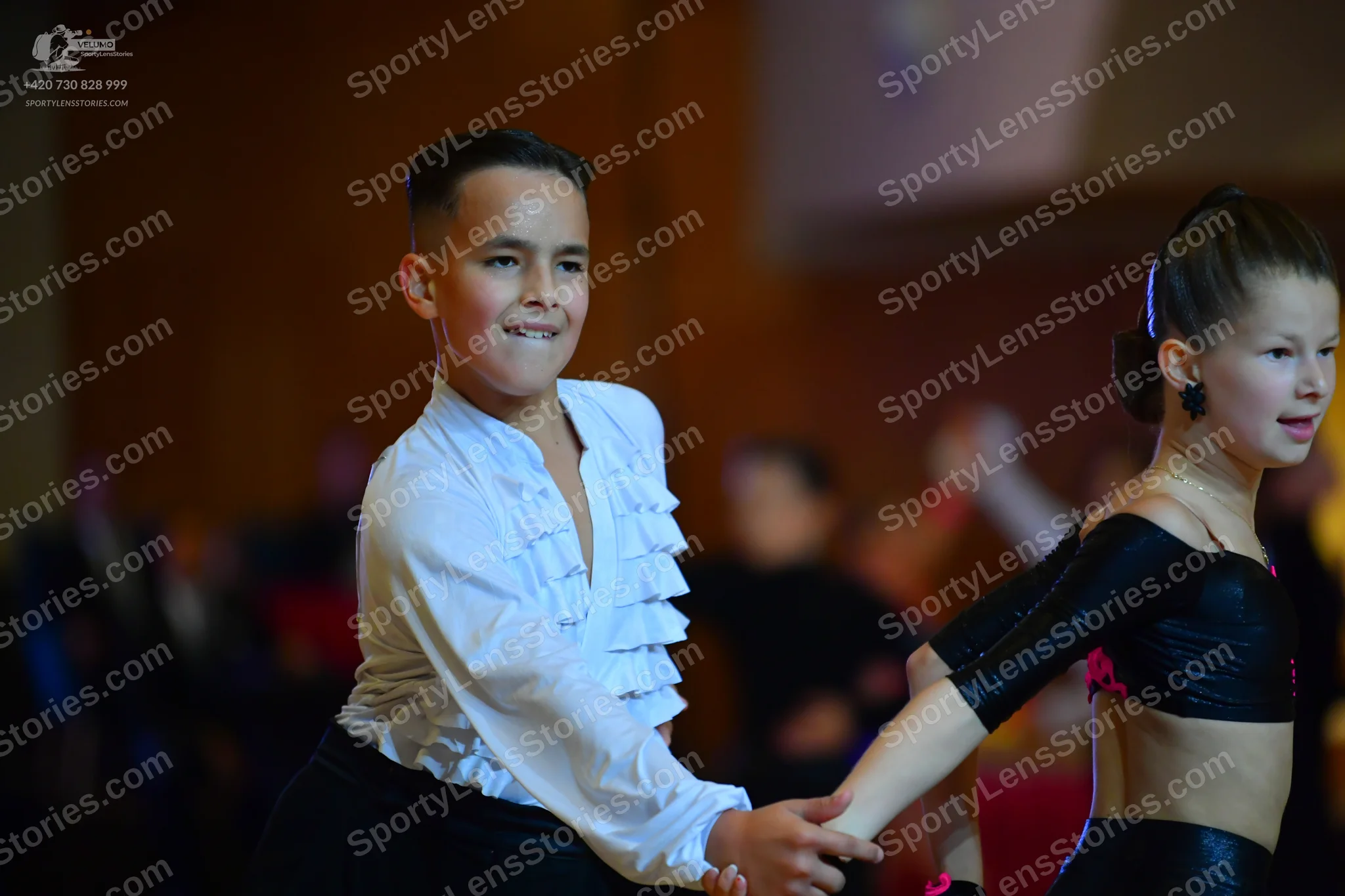Dancesport competitor: Male dancer: white long-sleeved shirt with ruffles down the front and black trou