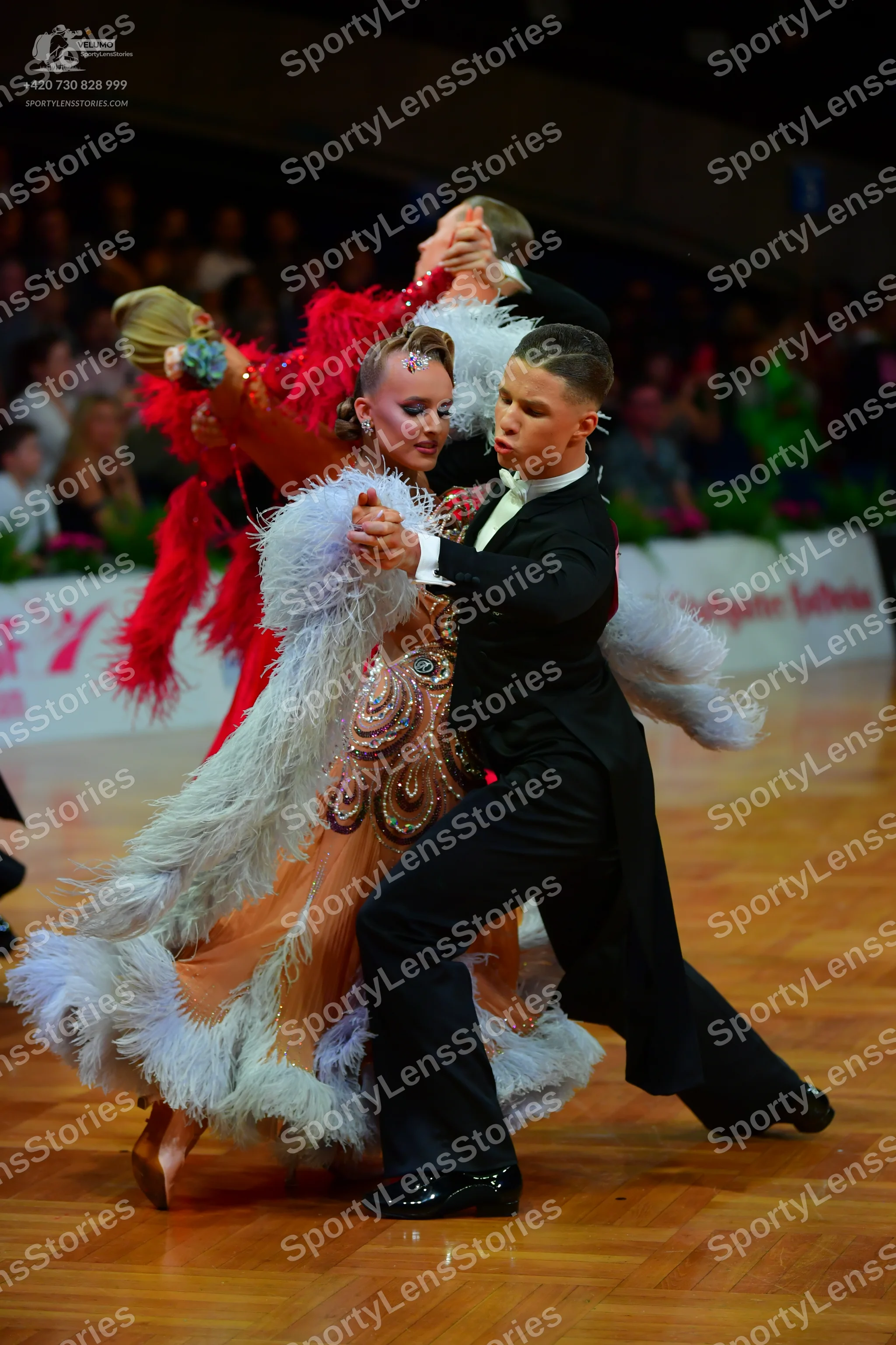 Dancesport competitor: Female dancer: Elaborate peach-colored Latin dance dress heavily embellished wit