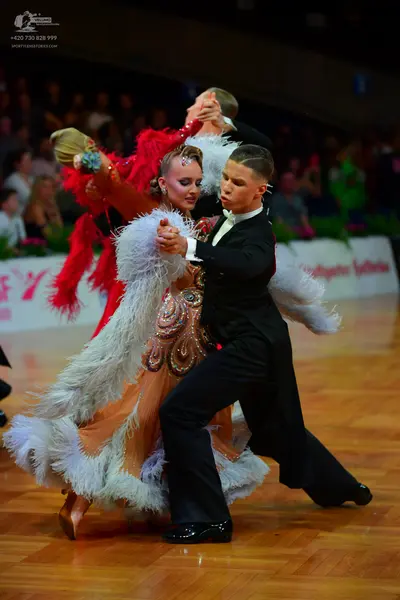 Dancesport competitor: Female dancer: Elaborate peach-colored Latin dance dress heavily embellished wit