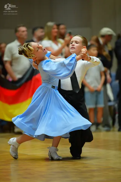Dancesport competitor: Female dancer: light blue long-sleeved ballgown with a flowing skirt