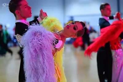 Dancesport competitor: Male dancer (left): black suit, white shirt, and black bowtie