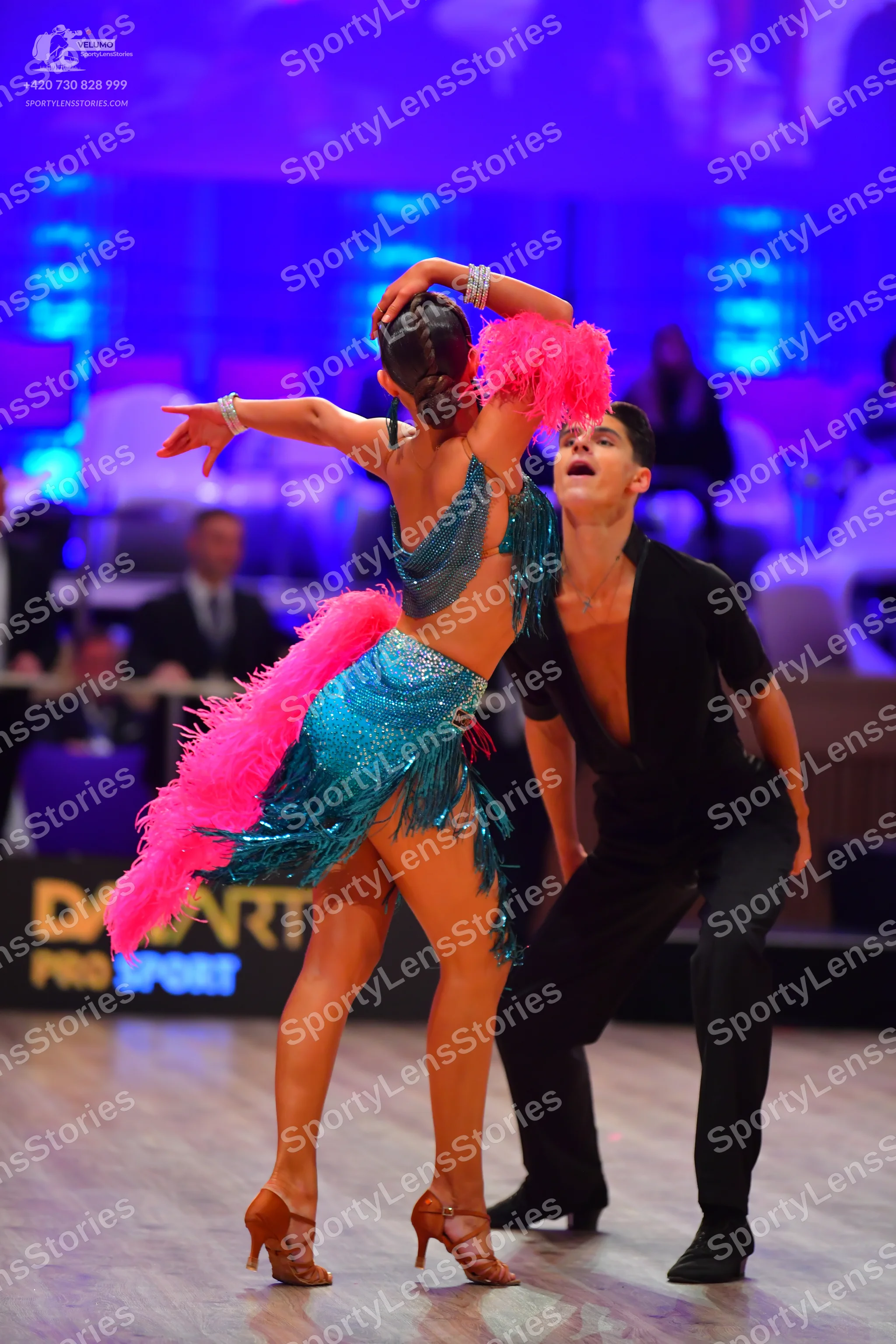 Dancesport competitor: Female dancer: teal Latin dance dress with sequins and long pink fringe