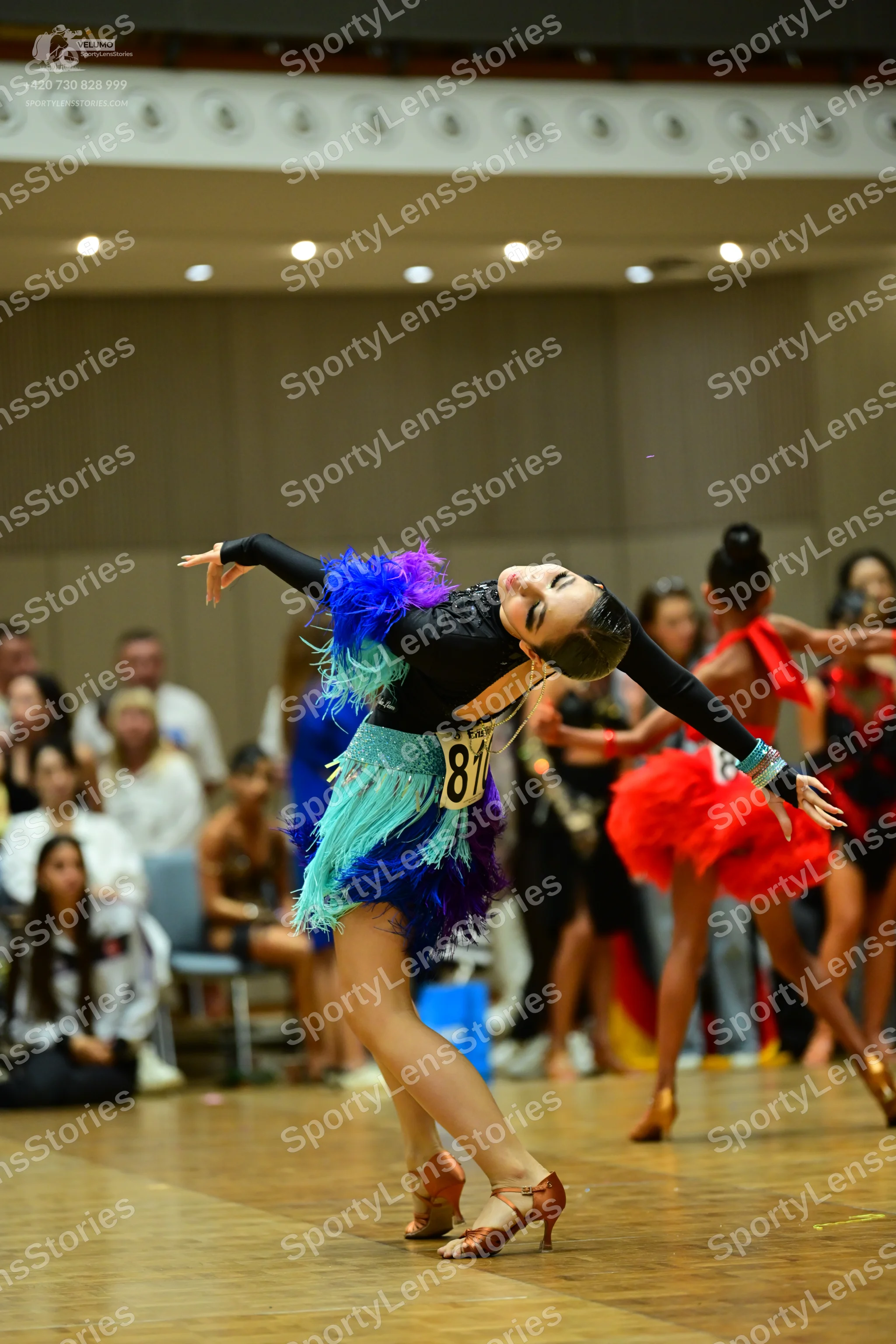 Dancesport competitor #81: First dancer: black long-sleeved latin dance dress with a colorful skirt featuri