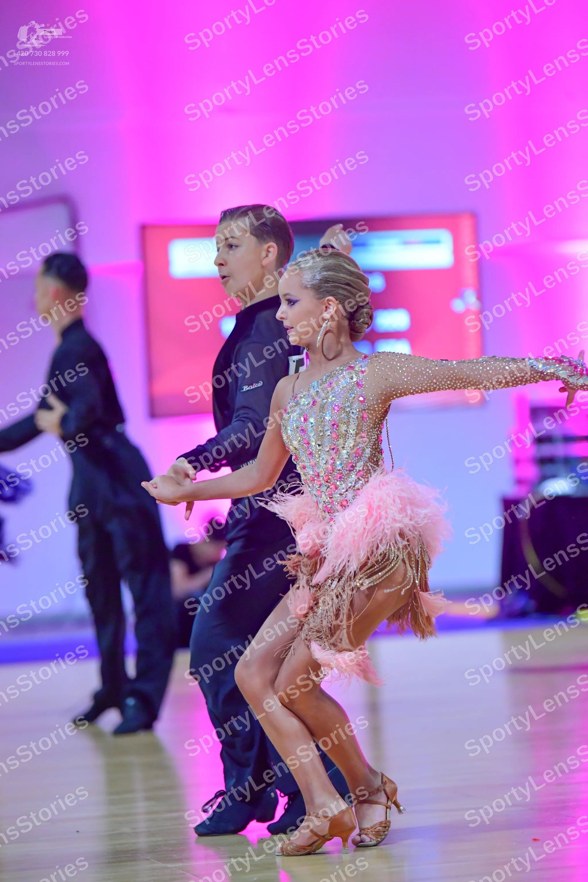 Dancesport competitor: Female dancer: light pink/nude Latin dress with heavy colorful sequins and beadi