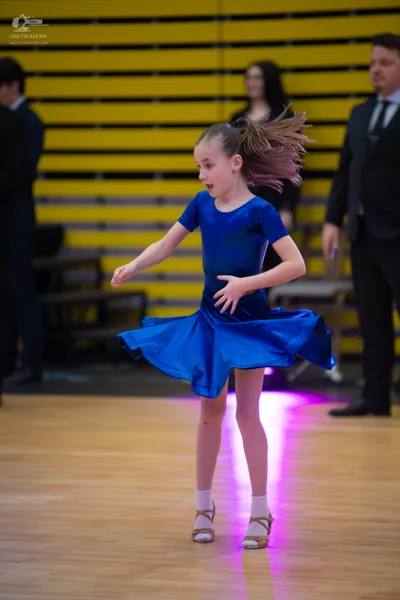 Dancesport competitor: ** Blue Latin Dress
*   **Fabric:** Shiny, likely satin or a similar smooth fabr