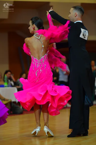 Dancesport competitor #42: Female dancer: bright pink latin dress with sequins and large pink feathers
