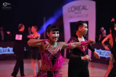 Dancesport competitor: Female dancer: bright pink Latin dance costume with heavy fringe and sequins