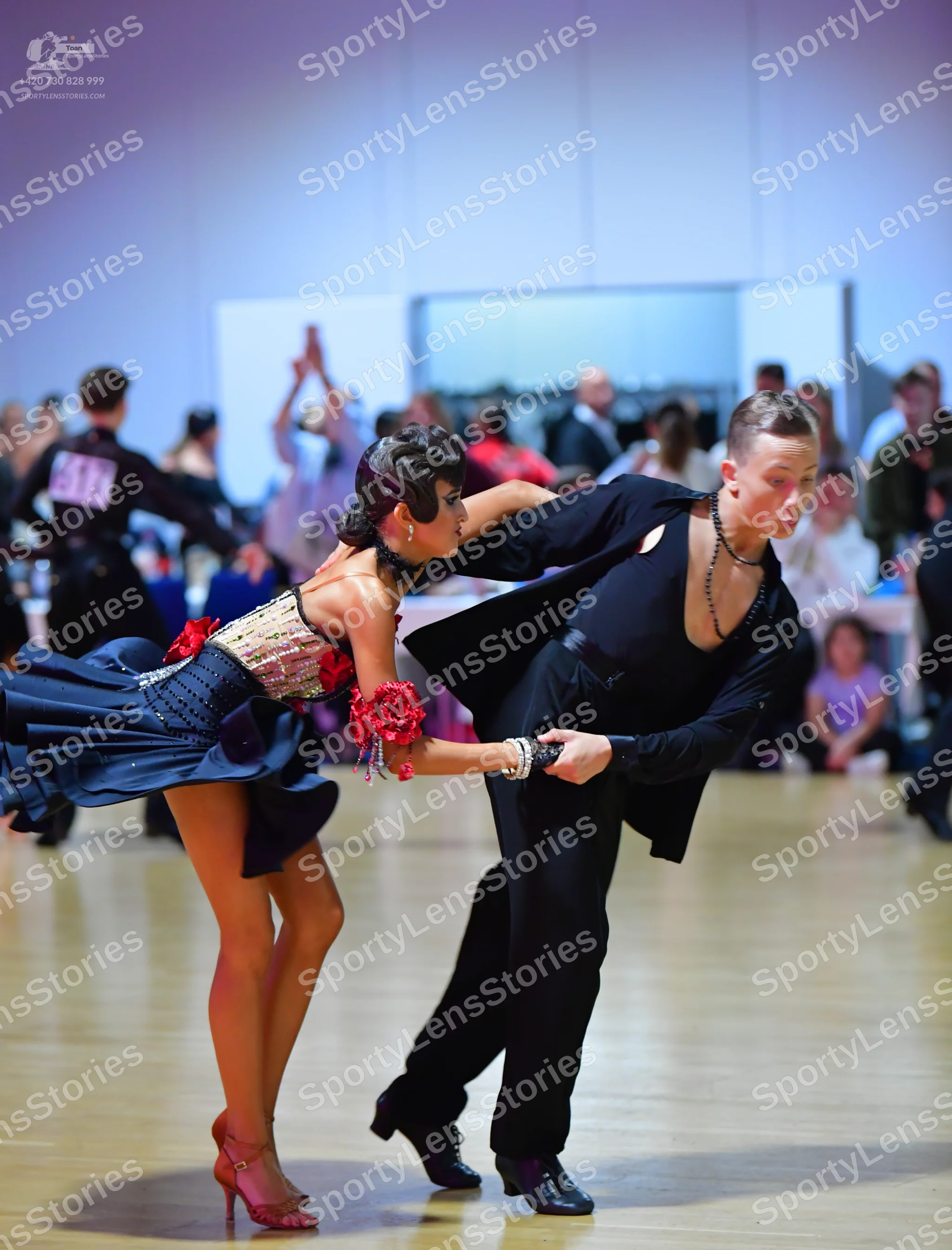Dancesport competitor #115: Male dancer: black latin dance outfit including a jacket, deep V-neck shirt, and