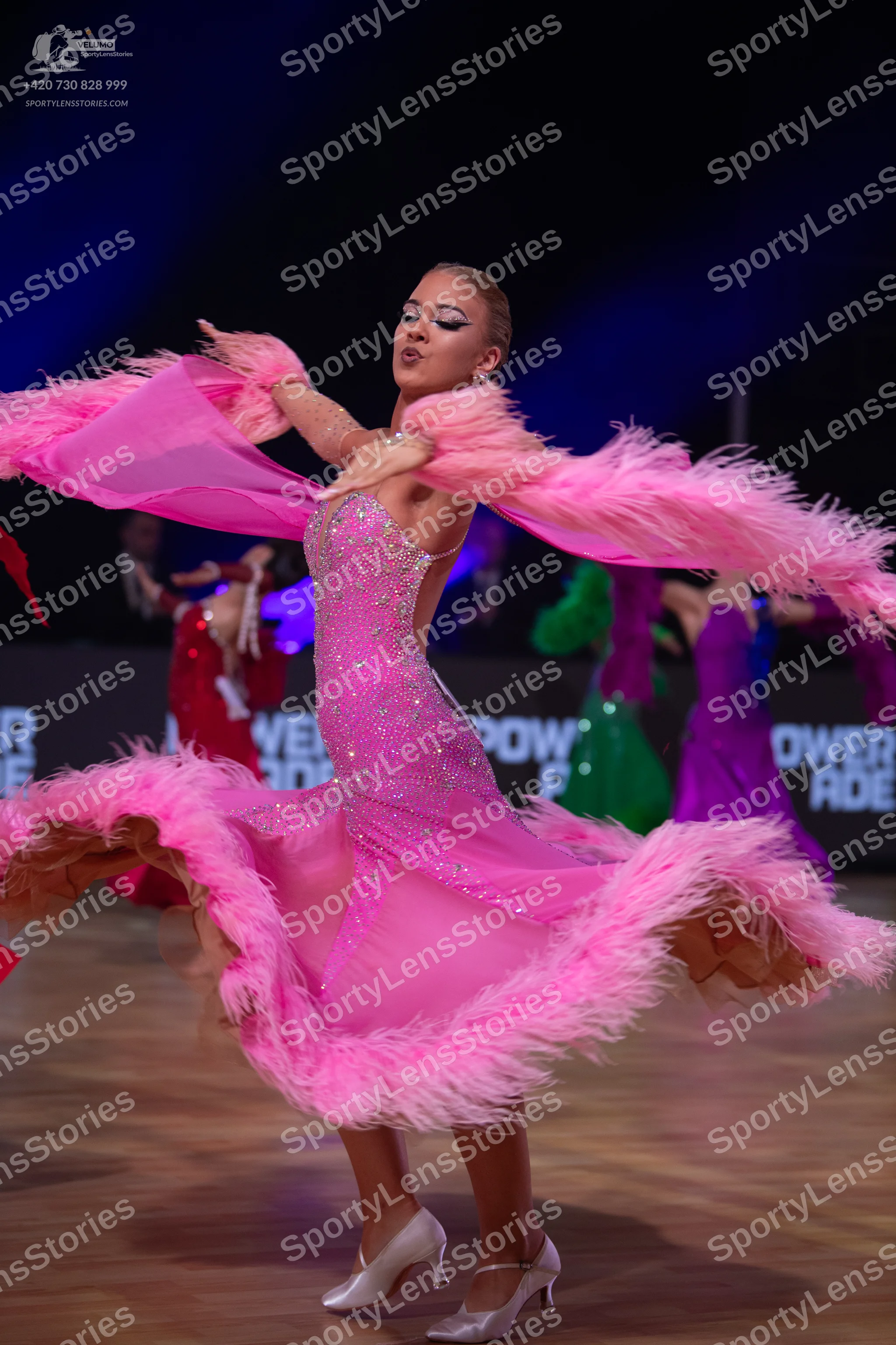 Dancesport competitor: Main dancer: pink sequined Latin dress with large pink feather-trimmed sleeves/a