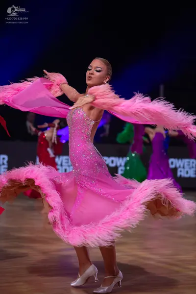 Dancesport competitor: Main dancer: pink sequined Latin dress with large pink feather-trimmed sleeves/a