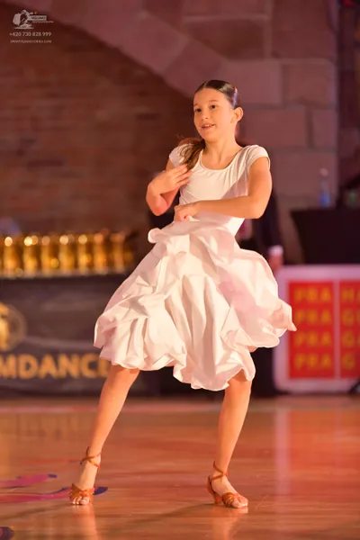Dancesport competitor: Female dancer: white ballroom dress with a voluminous, ruffled, multi-layered sk