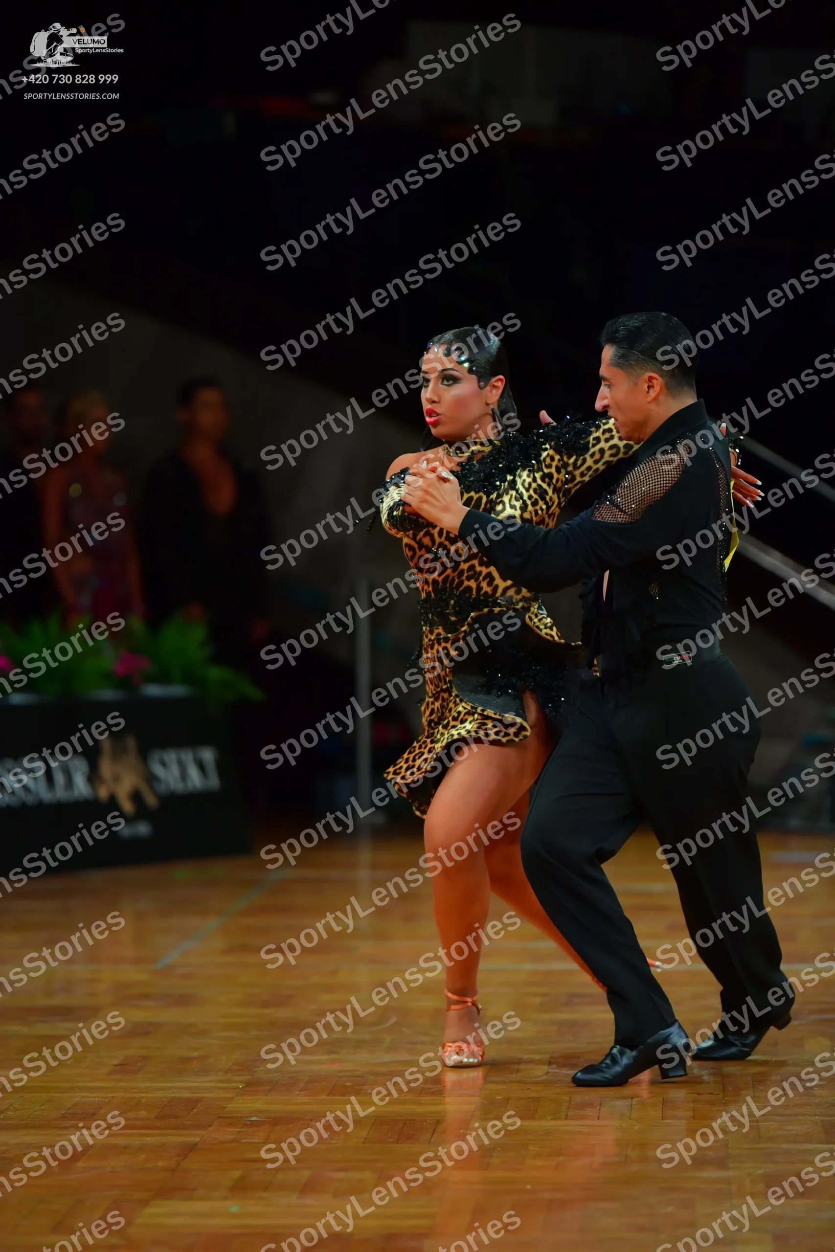 Dancesport competitor: Male dancer: black long-sleeved shirt with sheer mesh panels and black trousers