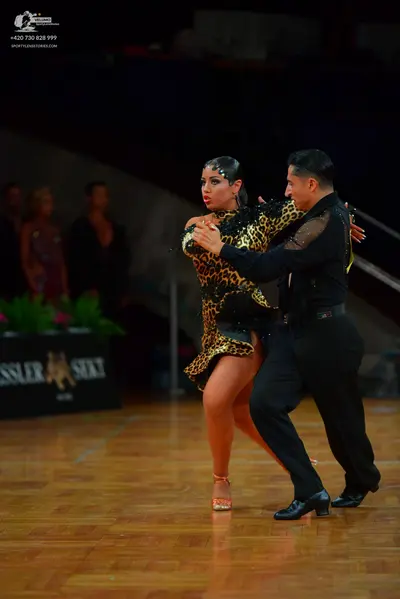 Dancesport competitor: Male dancer: black long-sleeved shirt with sheer mesh panels and black trousers
