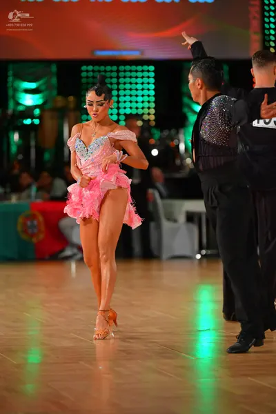 Dancesport competitor: Female dancer: light pink latin dress with a sequined bodice and ruffled skirt