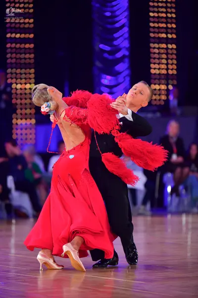 Dancesport competitor: Female dancer: red latin dress with large red feather-like fringe on the shoulde