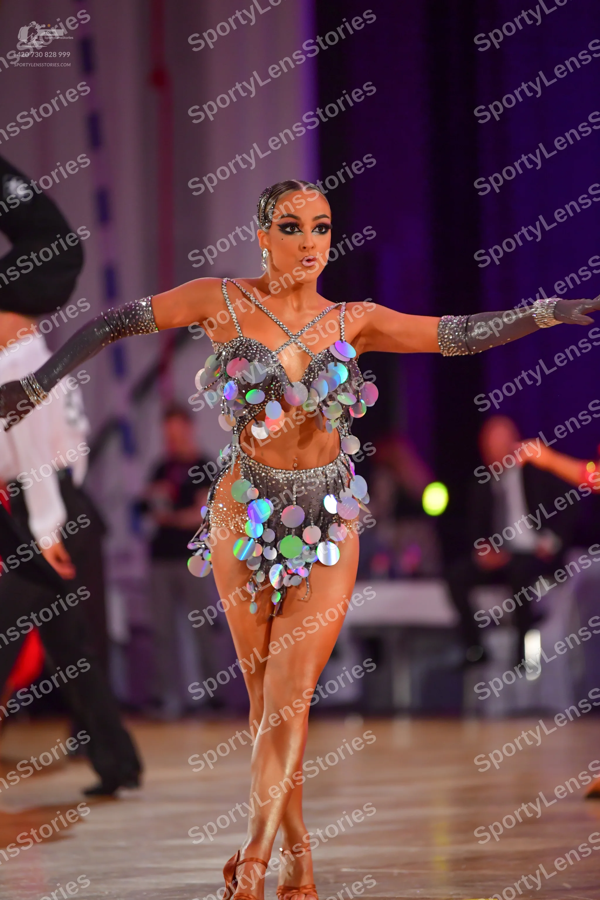 Dancesport competitor: Female dancer: silver metallic Latin dance costume featuring a bra top and a min