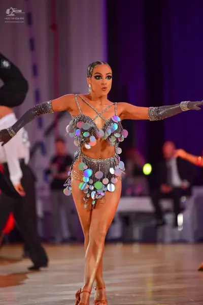 Dancesport competitor: Female dancer: silver metallic Latin dance costume featuring a bra top and a min
