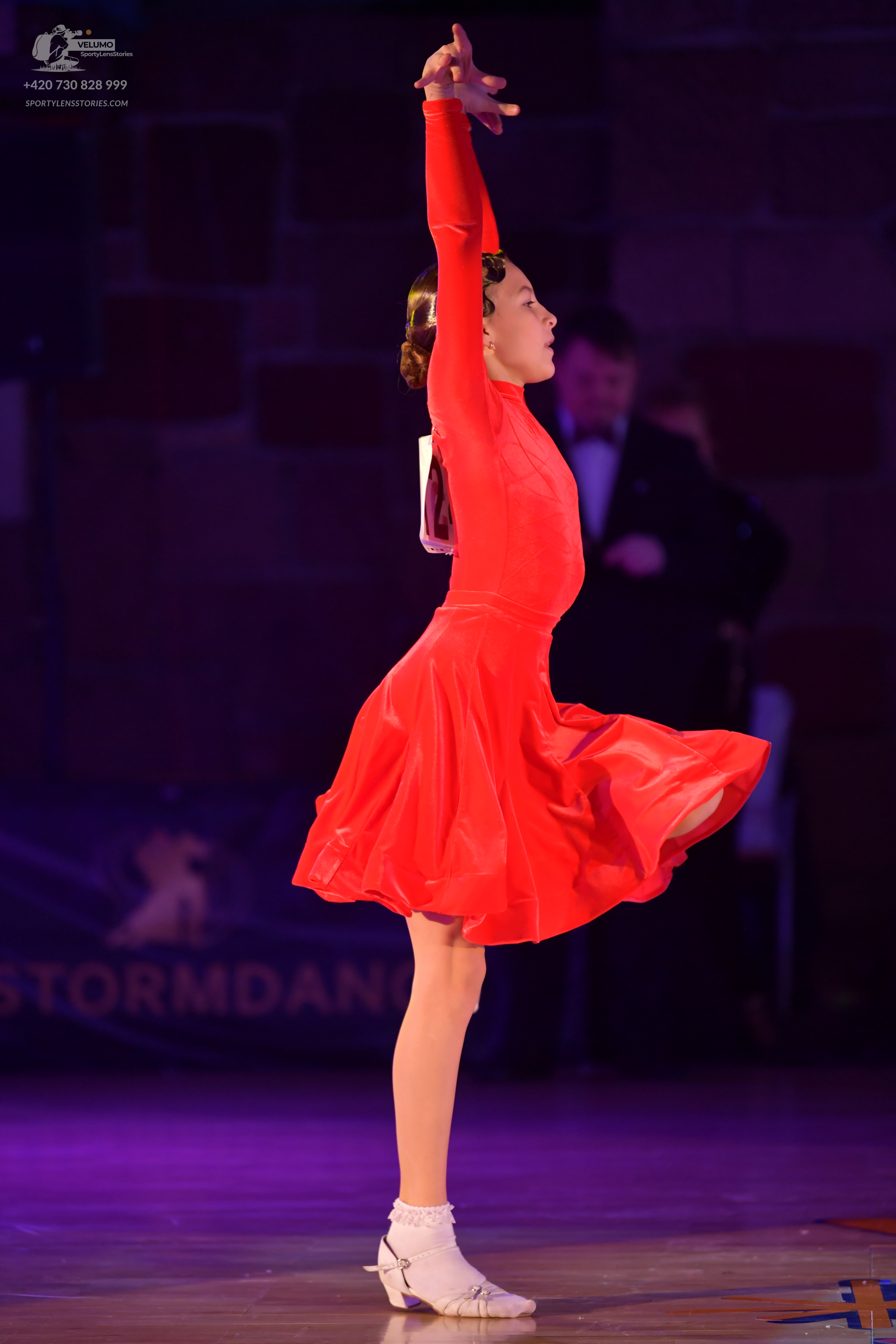 Dancesport competitor: Female dancer: red long-sleeved latin dress with a flared skirt and shiny fabric