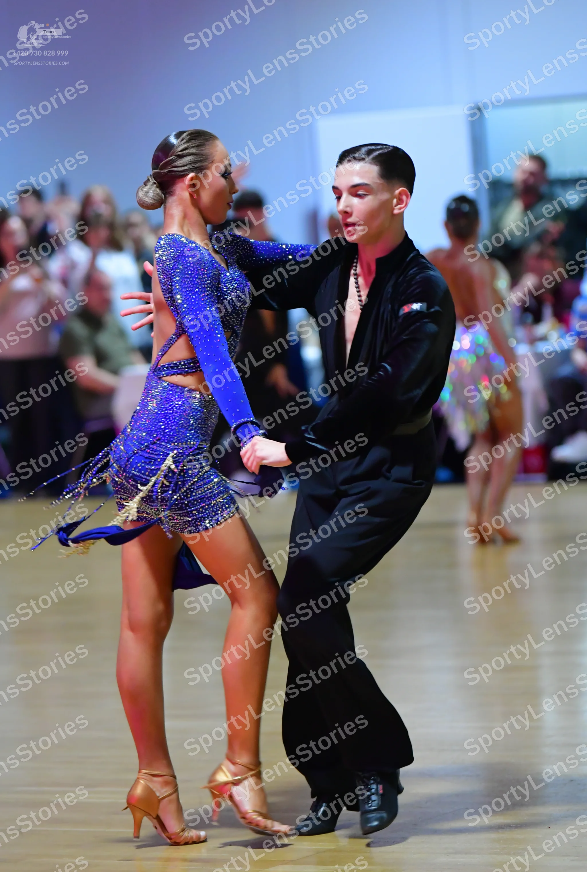 Dancesport competitor: Female dancer: royal blue Latin dance dress, heavily embellished with sequins an